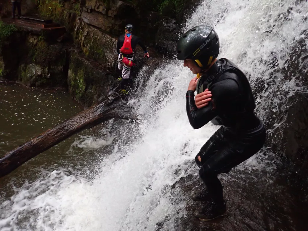 Young boy preparing top jump into a waterfall on youth outdoor activity